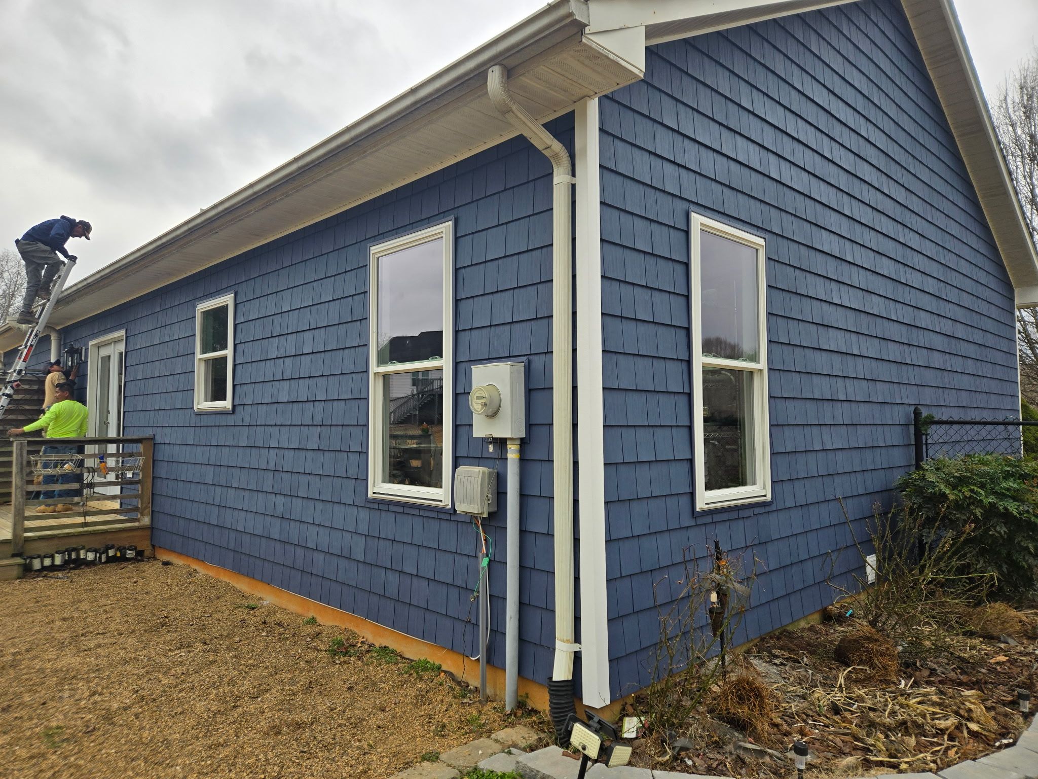Blue siding with white gutters and downspouts.